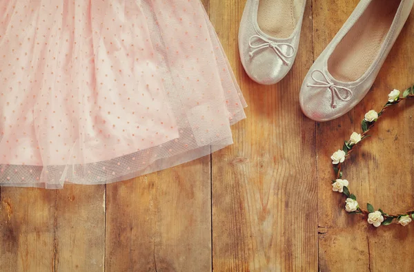 Vestido da menina chiffon vintage, tiara floral ao lado de sapatos de balé em fundo de madeira. imagem filtrada vintage — Fotografia de Stock