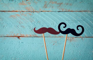 ahşap arka plan önünde sopa içinde kağıt bıyık. Vintage filtre uygulanmış görüntü