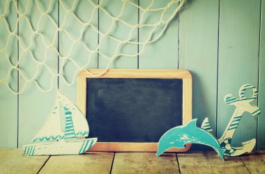 Deniz yaşam tarzı nesneleri ve boş yazı tahtası ahşap masa üzerinde