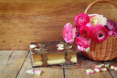 eski kitap ve gözlük ahşap masaya güzel alan çiçek yanında. Filtre vintage