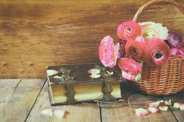 eski kitap ve gözlük ahşap masaya güzel alan çiçek yanında. Filtre vintage
