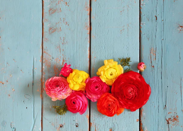 Draufsicht auf bunte Frühlingsblumen auf blauem Holzhintergrund. Jahrgang gefiltert — Stockfoto