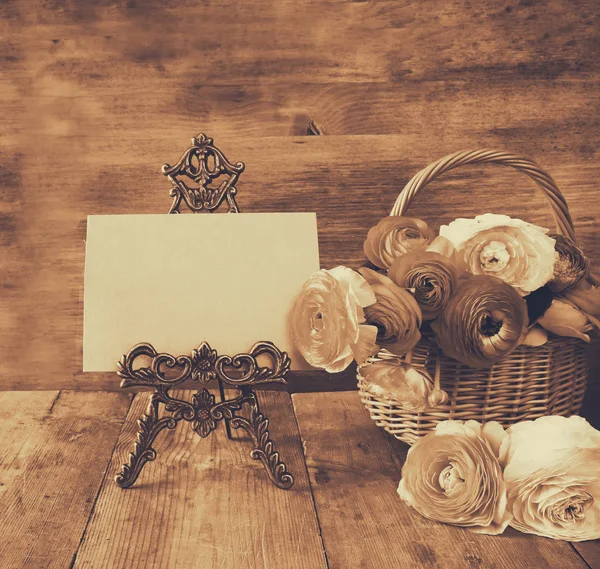 Rosa blommor i korgen bredvid tomma kort, på träbord. glad mors dag koncept. kopia utrymme — Stockfoto