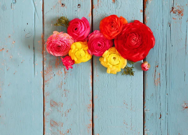 Draufsicht auf bunte Frühlingsblumen auf blauem Holzhintergrund. Jahrgang gefiltert — Stockfoto