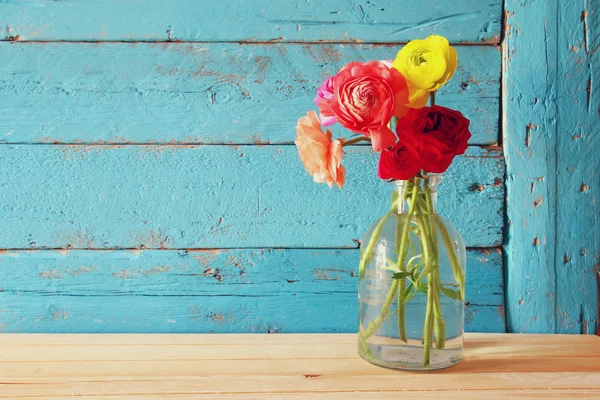 Fotoğraf mavi ahşap arka plan üzerinde renkli bahar çiçekleri. Filtre vintage — Stok fotoğraf