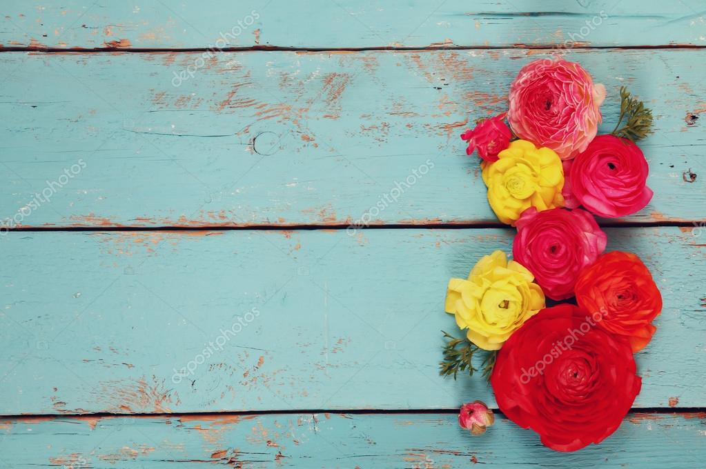 Top view of colorful spring flowers on blue wooden background. vintage