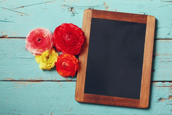 Çiçekler yanındaki boş yazı tahtası — Stok fotoğraf