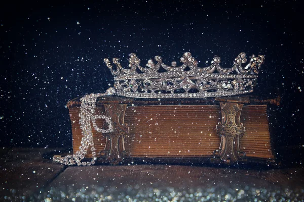 Lage belangrijke afbeelding van decoratieve kroon op oude boek. Vintage gefilterd — Stockfoto