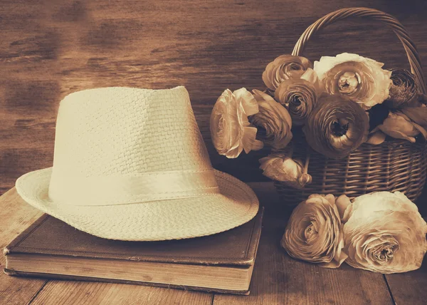 Chapéu fedora ao lado de livro velho e flores na mesa de madeira. sépia v — Fotografia de Stock