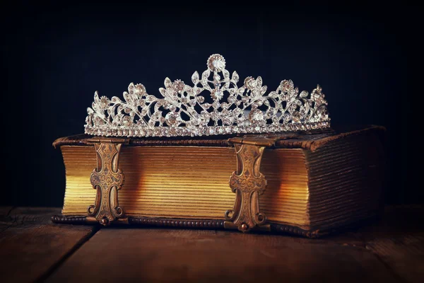 low key image of decorative crown on old book