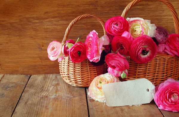 나무 테이블에 빈 카드 옆 바구니에 분홍색 꽃. — 스톡 사진