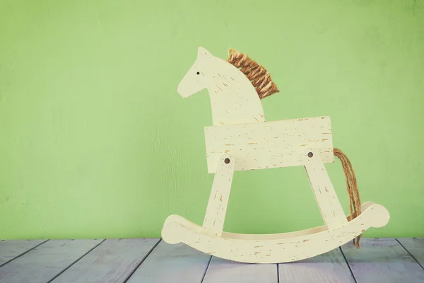 Cavalo de balanço vintage no chão de madeira. imagem retro filtrada — Fotografia de Stock