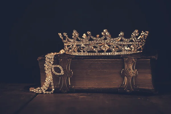 Low key image of beautiful diamond queen crown on old book — Stock Photo, Image