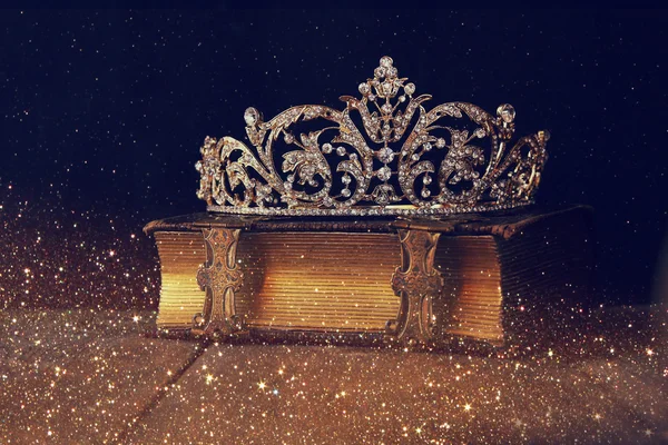 Low key image of beautiful diamond queen crown on old book — Stock Photo, Image