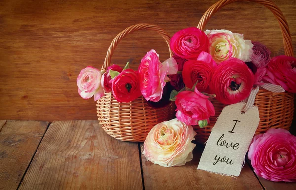Fleurs roses à côté de la carte avec phrase : Je t'aime — Photo