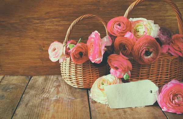 Flores cor-de-rosa na cesta ao lado do cartão vazio — Fotografia de Stock