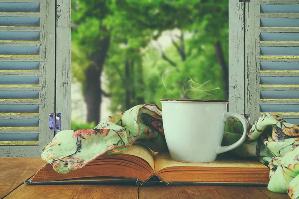 Romantic scene of cup of coffee next to old book — Stock Photo, Image