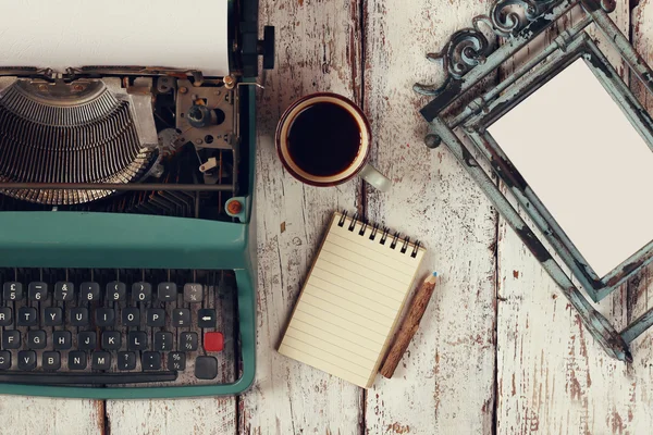 Imagen de máquina de escribir vintage y marco en blanco en mesa de madera —  Fotos de Stock