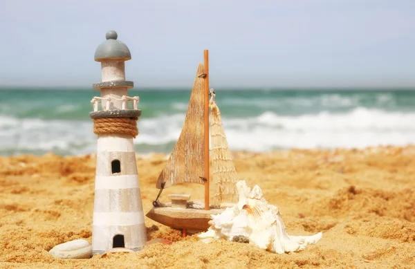 Faro, velero sobre arena marina y horizonte oceánico . —  Fotos de Stock