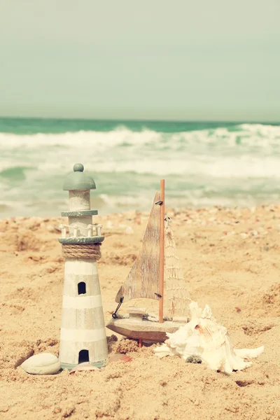 Faro, velero sobre arena marina y horizonte oceánico . — Foto de Stock