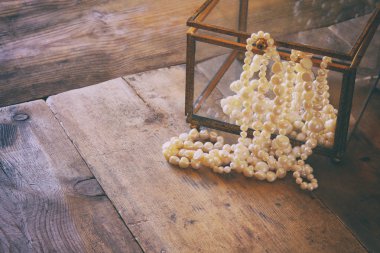 white pearls necklace on grunge wooden table
