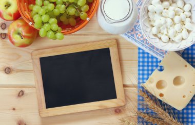image of dairy products and fruits next to empty blackboard