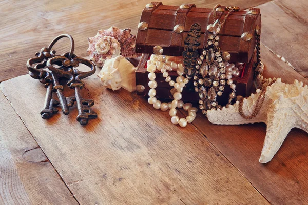 White pearls necklace in treasure chest next to seashells — 스톡 사진