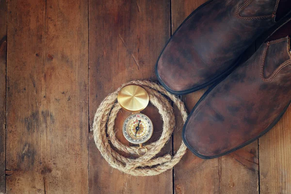 Brújula, cuerda, botas de senderismo y viejo sobre la mesa — Foto de Stock