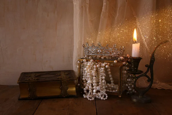 Królowa Korona, białe perły obok starej książki — Zdjęcie stockowe