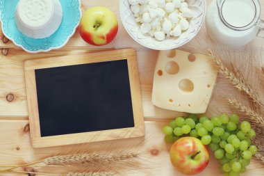 image of dairy products and fruits next to empty blackboard