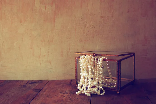 Низкий ключевой образ белого жемчуга ожерелье на деревянный стол — стоковое фото