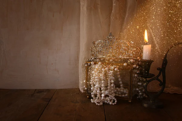 Corona reina de diamantes, perlas blancas junto a la vela ardiente — Foto de Stock