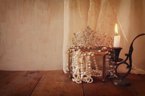 Corona reina de diamantes, perlas blancas junto a la vela ardiente — Foto de Stock