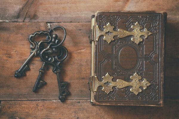 top view of antique book cover and old keys