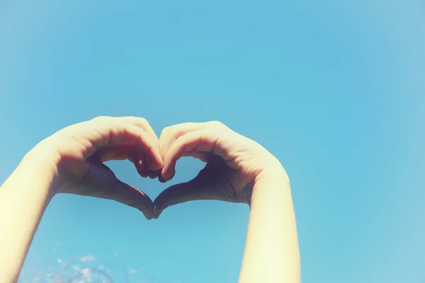 Silhouette of heart made by kids hand agianst sky — Stock Photo, Image