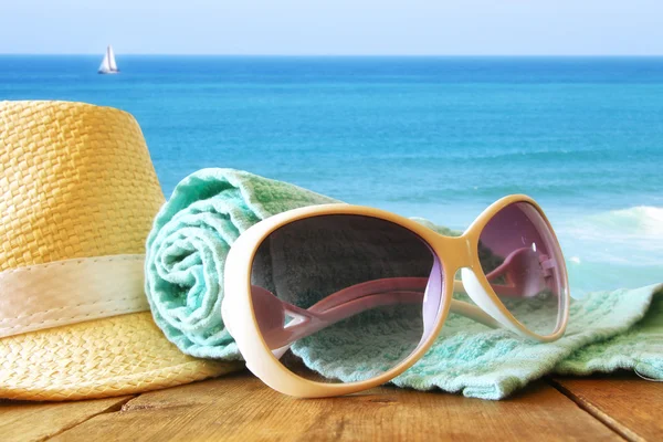 Chapeau fedora et lunettes de soleil sur table en bois — Photo