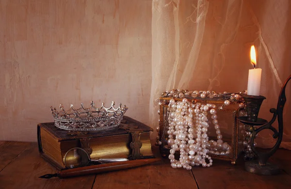 Imagem da coroa rainha, pérolas brancas ao lado do livro velho — Fotografia de Stock