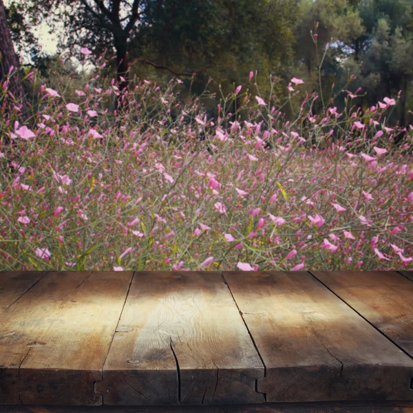 Träbord framför blommor i skogen — Stockfoto