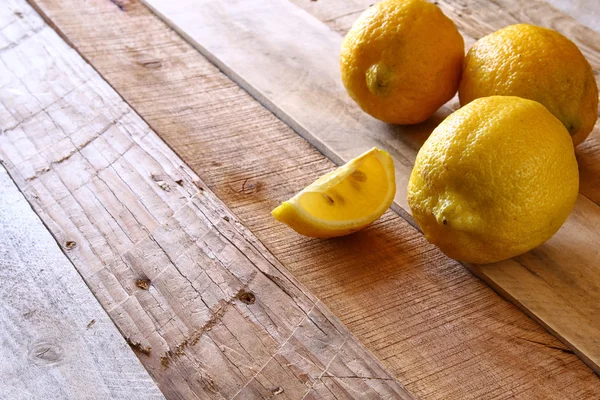 Obrázek z čerstvých citronů na rustikální dřevěný stůl — Stock fotografie