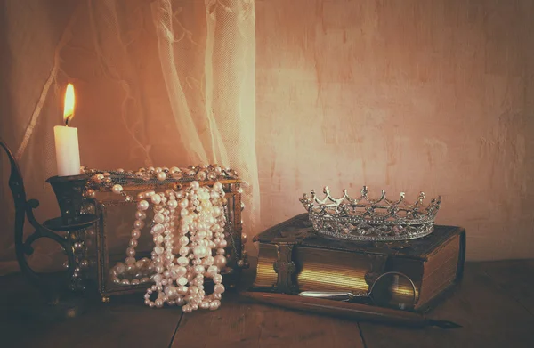 Clé basse de couronne reine, perles blanches à côté de vieux livre — Photo