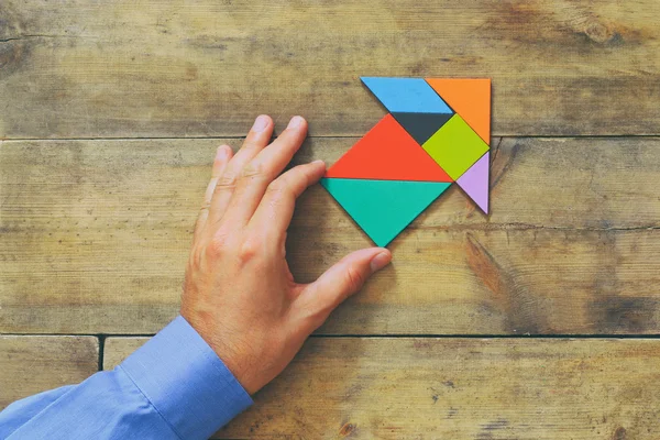 Férfi kezét készült tangram puzzle nyíl mutat — Stock Fotó