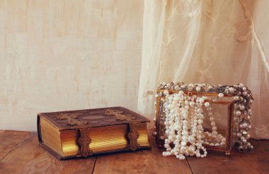 Beyaz İnci kolye ve eski kitap 