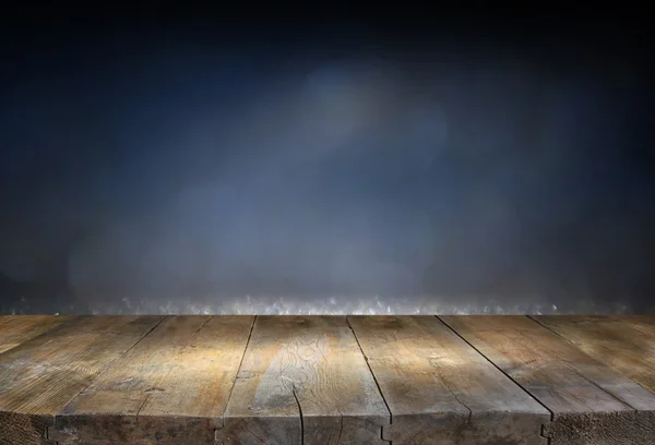Изображение деревянного стола перед блестящими огнями фона — стоковое фото