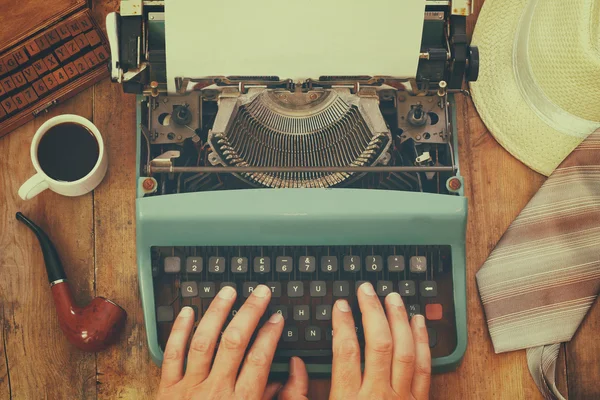 Hombre escribiendo en máquina de escribir vintage con página en blanco —  Fotos de Stock