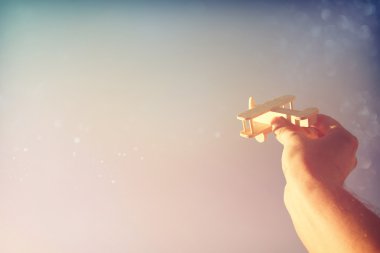 Adamın elini gökyüzüne karşı ahşap oyuncak uçak holding