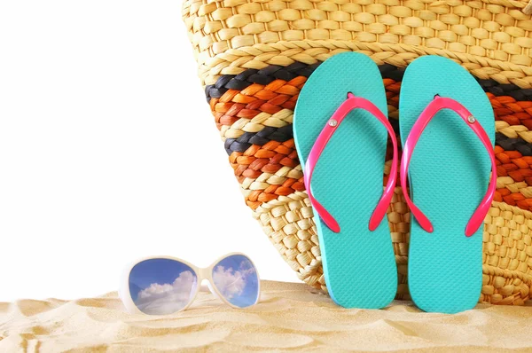 Тропический песчаный пляж, соломенная сумка, солнцезащитные очки и шлепанцы — стоковое фото