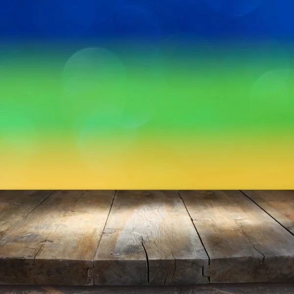 Empty table in front of abstract lights using brazil flag colors — Stock Photo, Image