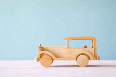 Vintage wooden toy car over wooden table clipart