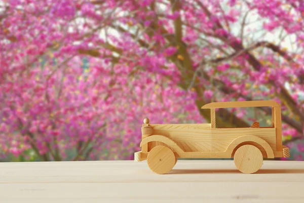 나무 테이블에 오래 된 나무로 되는 장난감 자동차. — 스톡 사진