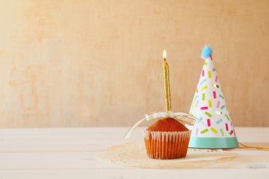 Doğum günü konseptiyle cupcake ve mum, parti şapkası